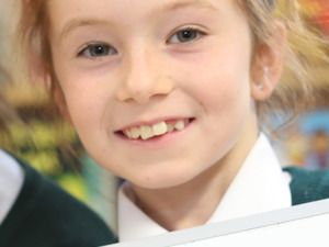 One child holding up maths support material