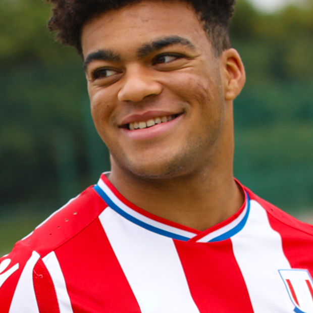 Student smiling outside in sports uniform
