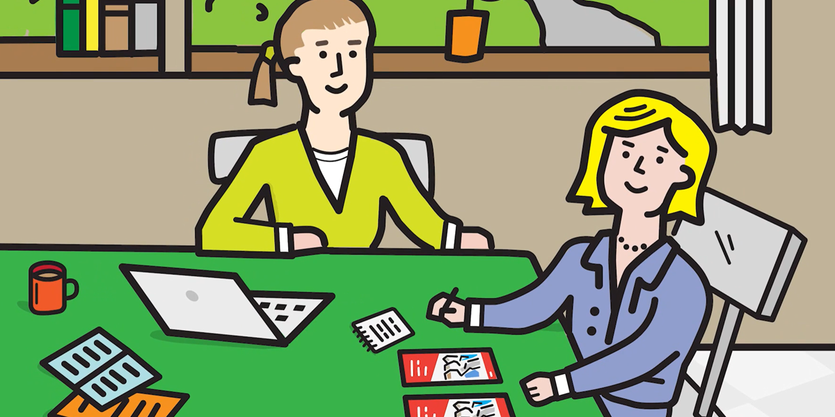 Image of two teachers sitting at desk planning. 