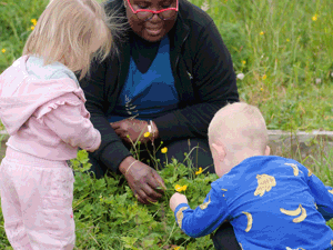 Adult and children looking at buttercups